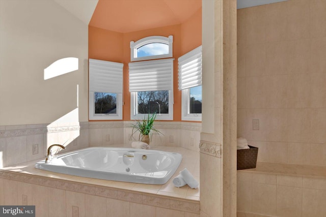 bathroom featuring vaulted ceiling and a relaxing tiled tub