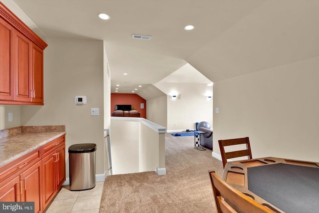 kitchen with lofted ceiling and light colored carpet