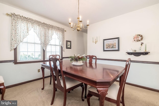 dining area with light carpet and a chandelier