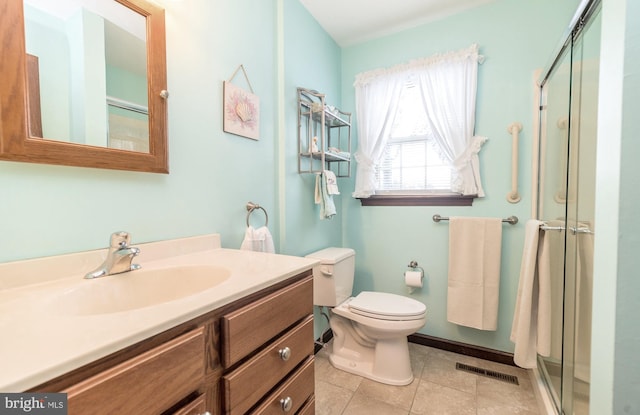 bathroom with vanity, tile patterned floors, a shower with door, and toilet