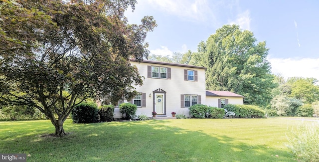 colonial inspired home featuring a front lawn