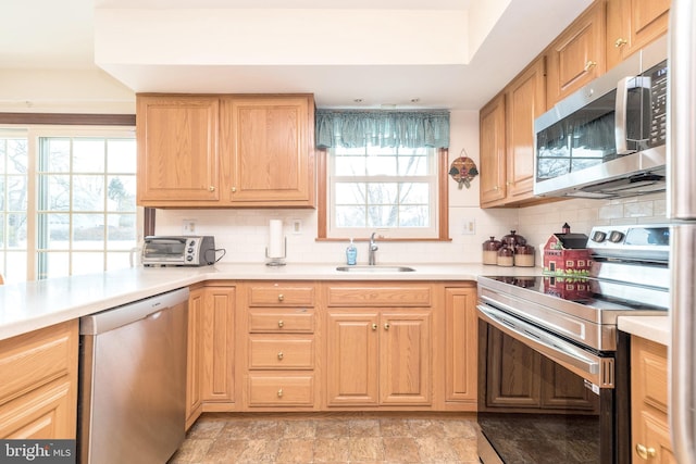 kitchen with tasteful backsplash, appliances with stainless steel finishes, and sink