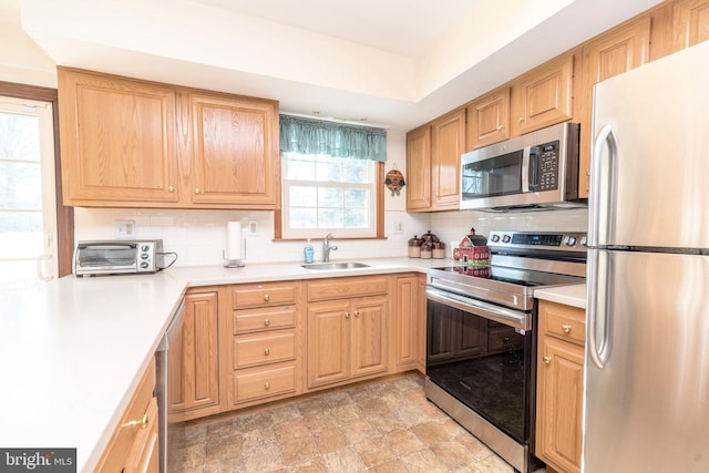 kitchen featuring stainless steel appliances, sink, and backsplash