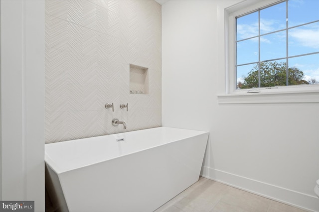 bathroom featuring tile patterned floors, a bathtub, and tile walls