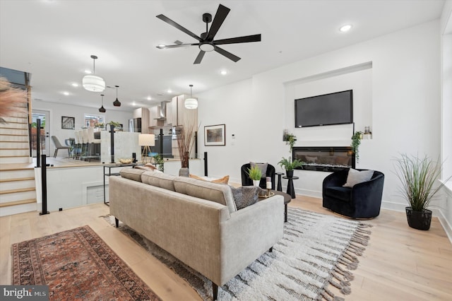 living room featuring light hardwood / wood-style flooring and ceiling fan