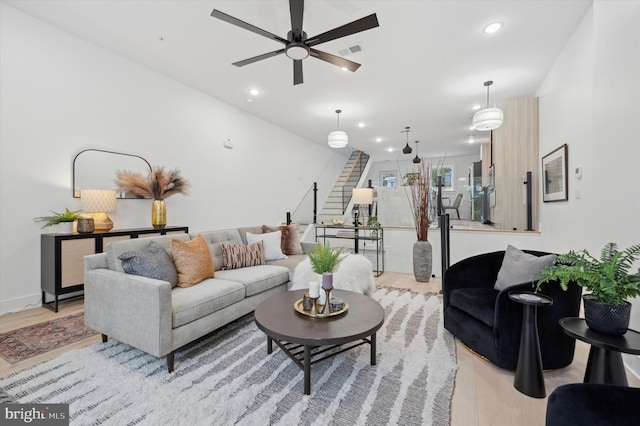 living room with ceiling fan and light hardwood / wood-style flooring