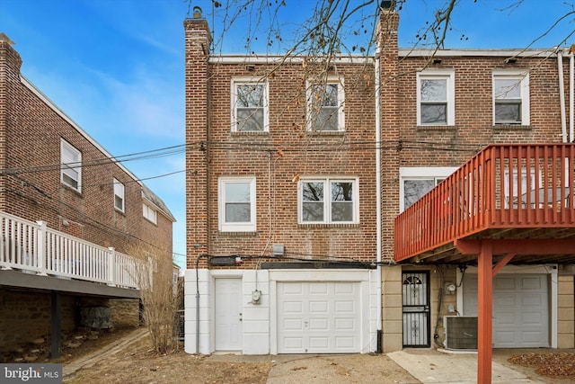 back of house featuring cooling unit and a garage