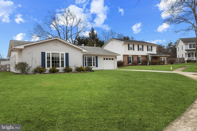 view of front of home with an attached garage, a front yard, and fence