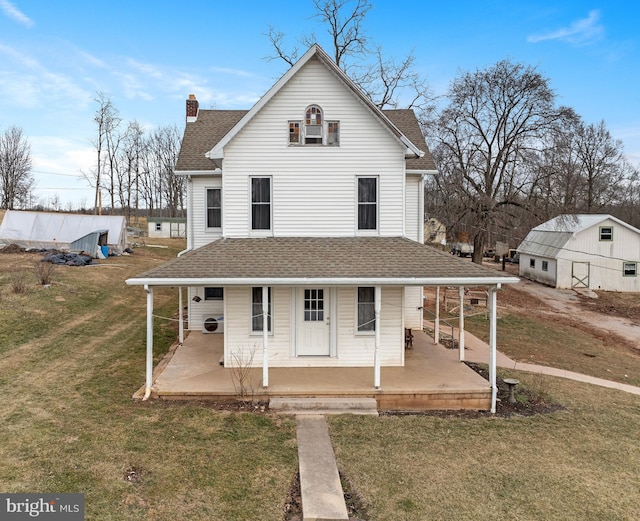 farmhouse-style home with covered porch, a front lawn, and roof with shingles