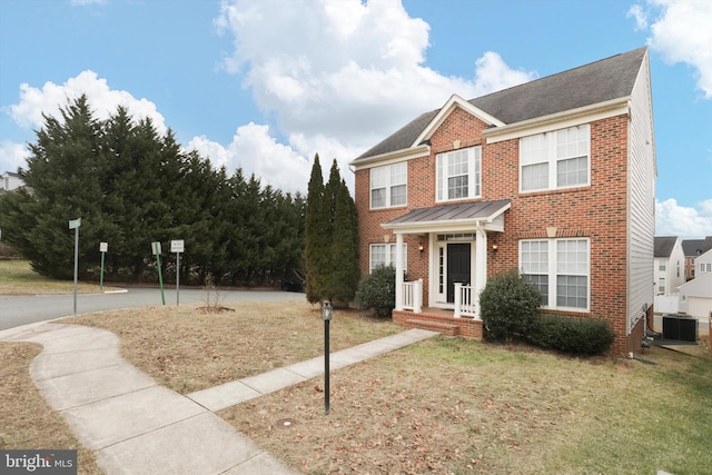 view of front of home with a front yard and central air condition unit