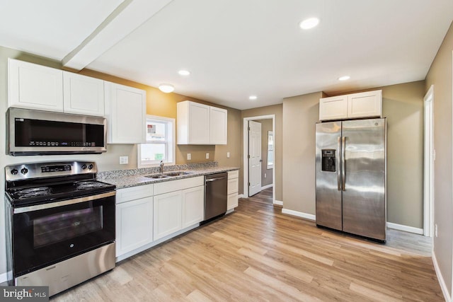 kitchen featuring stainless steel appliances, light hardwood / wood-style floors, sink, light stone counters, and white cabinets