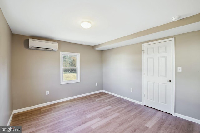 spare room featuring light hardwood / wood-style floors and an AC wall unit