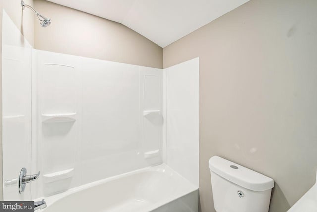 bathroom with vaulted ceiling, toilet, and bathing tub / shower combination