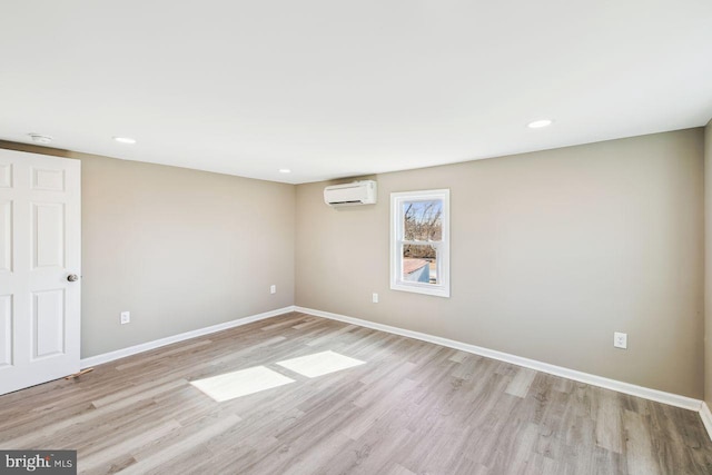 spare room with light wood-type flooring and a wall mounted AC