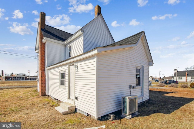 view of side of property with a yard and ac unit