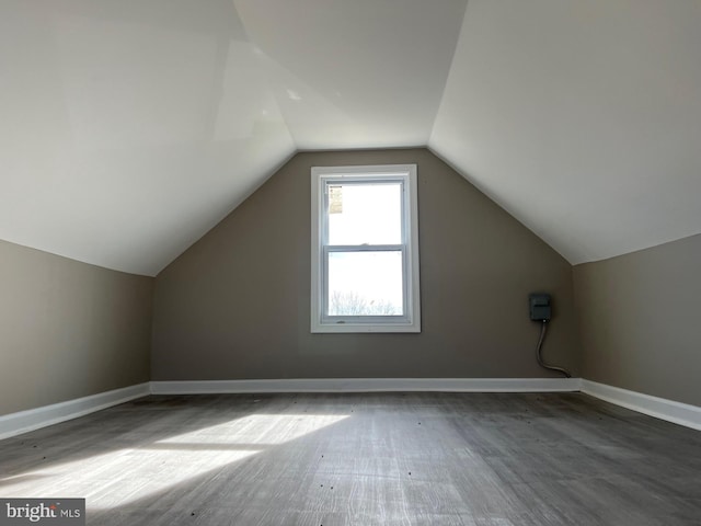 bonus room featuring dark wood-type flooring and vaulted ceiling