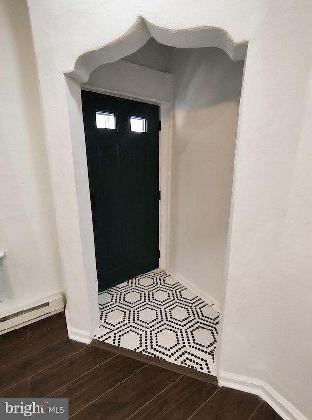 entryway with wood-type flooring and a baseboard heating unit