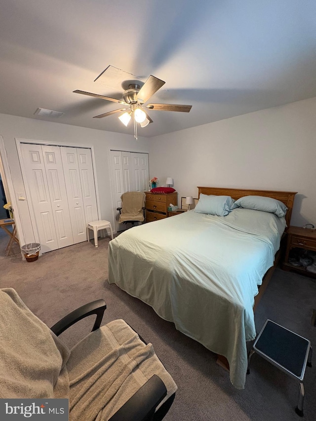 carpeted bedroom featuring multiple closets and ceiling fan