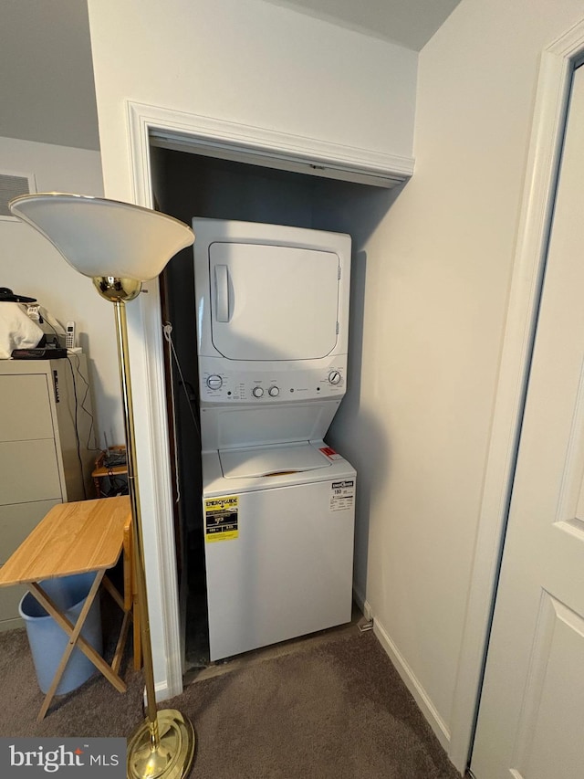 laundry area with stacked washing maching and dryer and dark carpet