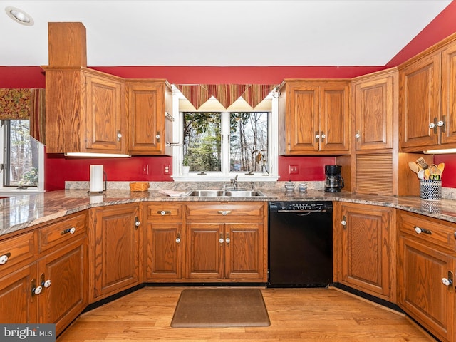 kitchen featuring light wood-type flooring, dishwasher, light stone counters, and sink