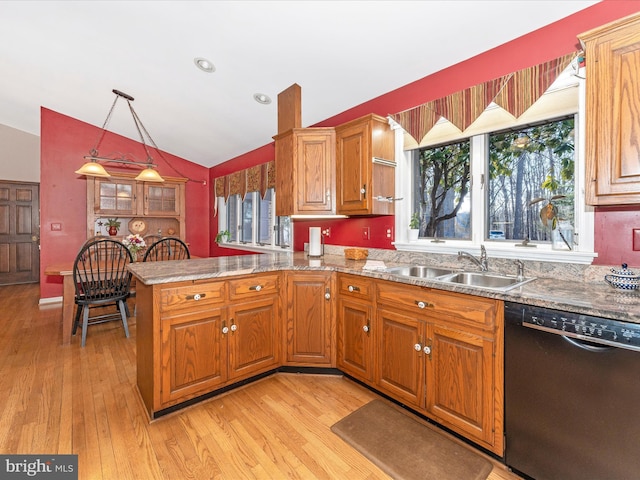 kitchen with dishwasher, lofted ceiling, decorative light fixtures, sink, and kitchen peninsula