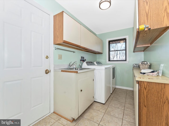 washroom featuring washer and dryer, cabinets, sink, and light tile patterned floors