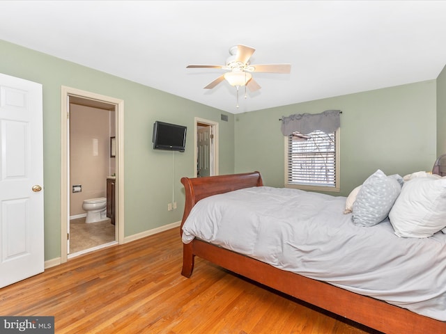 bedroom with ceiling fan, connected bathroom, and light hardwood / wood-style floors