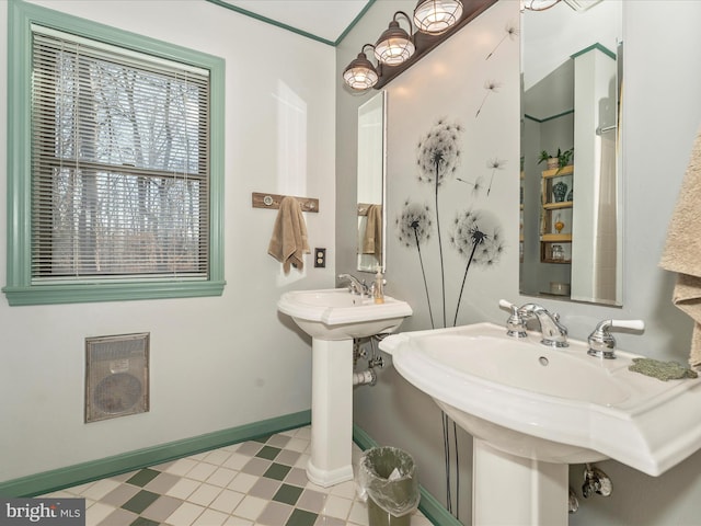 bathroom with heating unit and dual sinks