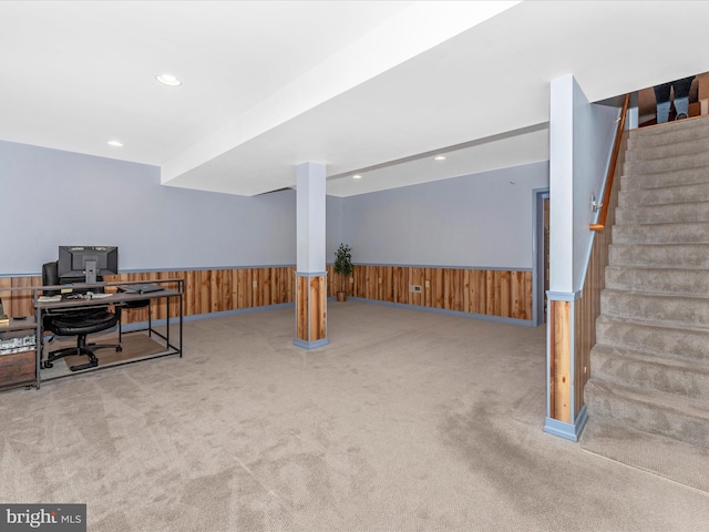 carpeted home office with wood walls