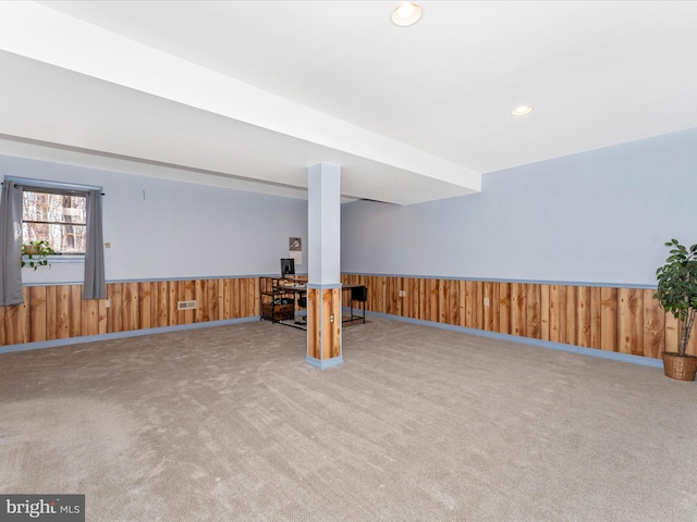 basement featuring carpet and wooden walls