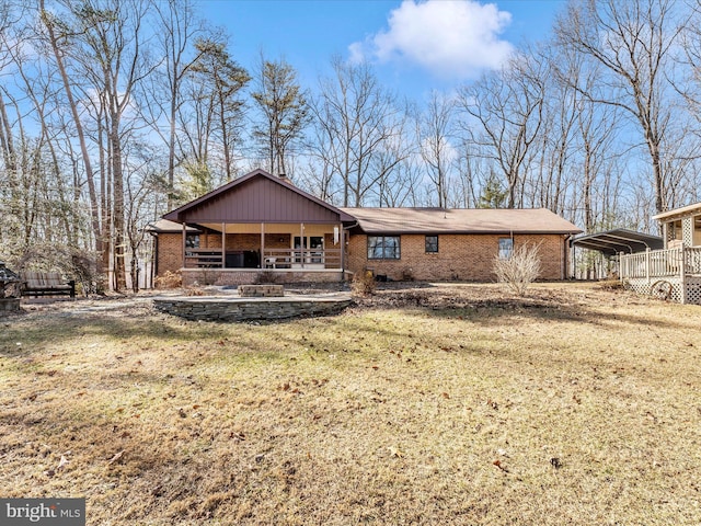 rear view of house with a yard and a carport