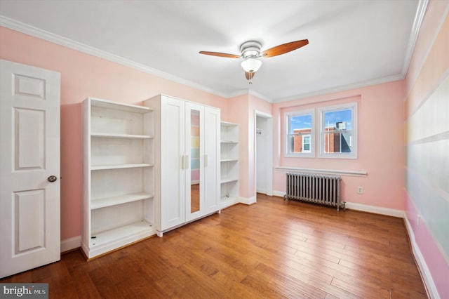 interior space featuring hardwood / wood-style flooring, radiator heating unit, ornamental molding, and ceiling fan