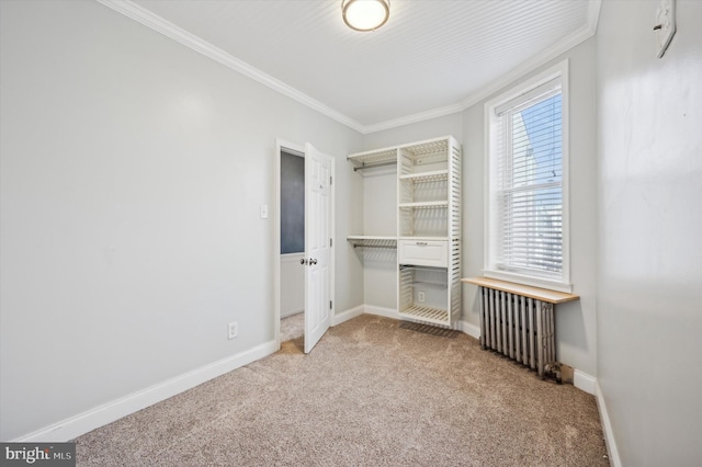 unfurnished bedroom featuring carpet floors, crown molding, radiator, and a closet