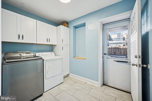 laundry area featuring cabinets, light tile patterned floors, and independent washer and dryer