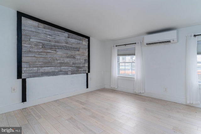 empty room featuring light hardwood / wood-style flooring and a wall mounted AC