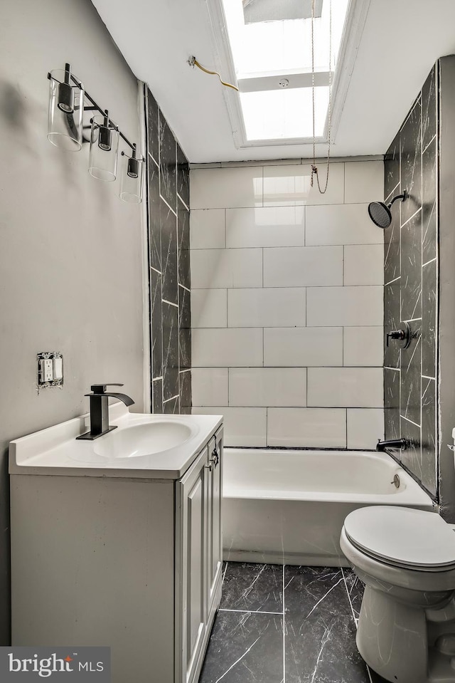 full bathroom featuring tiled shower / bath combo, vanity, and toilet