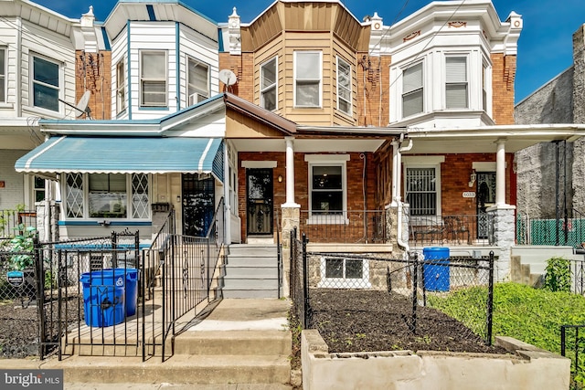 townhome / multi-family property featuring covered porch