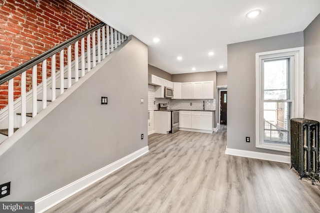 unfurnished living room with radiator and light hardwood / wood-style floors