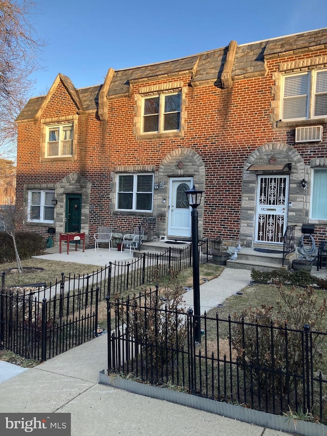 view of property featuring a fenced front yard, entry steps, and brick siding