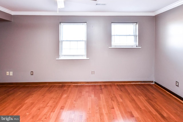 empty room featuring hardwood / wood-style flooring and ornamental molding