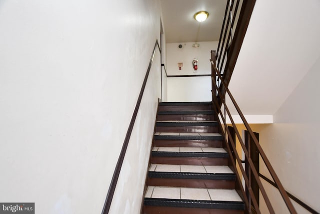 stairway with tile patterned floors