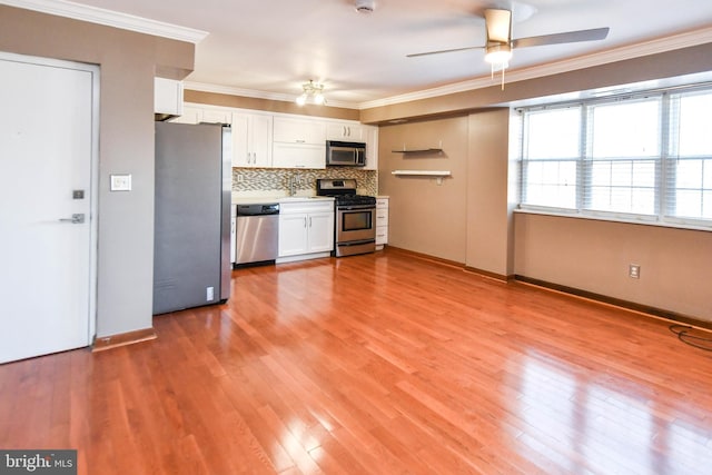 kitchen featuring ornamental molding, stainless steel appliances, light hardwood / wood-style flooring, and white cabinets