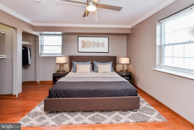 bedroom with ceiling fan, ornamental molding, light hardwood / wood-style floors, and a closet