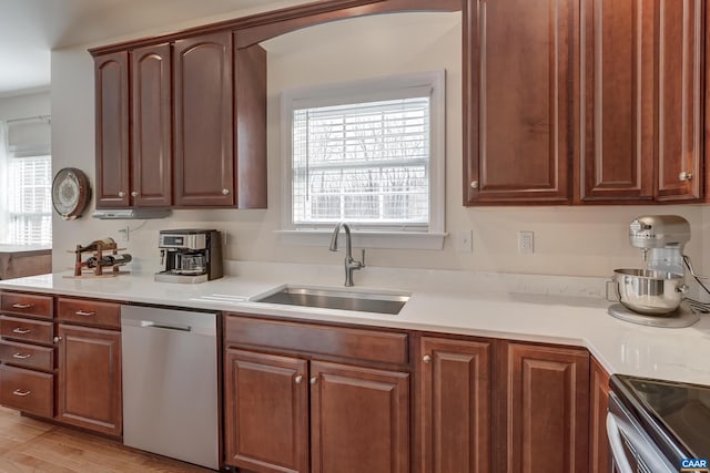 kitchen featuring stainless steel appliances, sink, and light hardwood / wood-style flooring