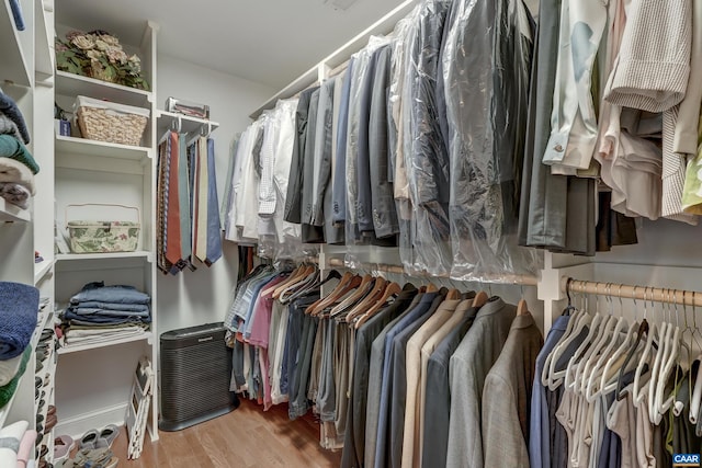 walk in closet with light hardwood / wood-style flooring