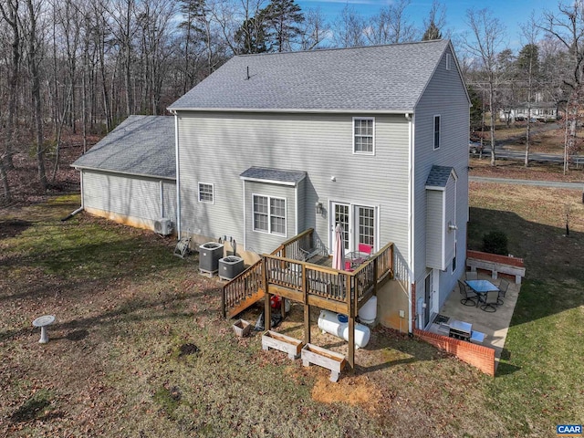 rear view of property featuring cooling unit, a yard, and a deck