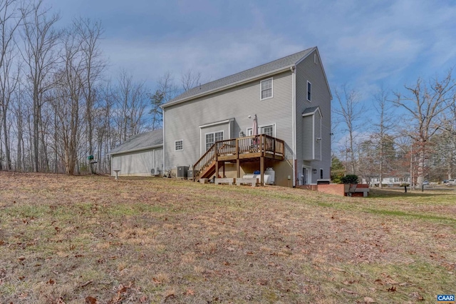 rear view of property featuring cooling unit, a deck, and a lawn