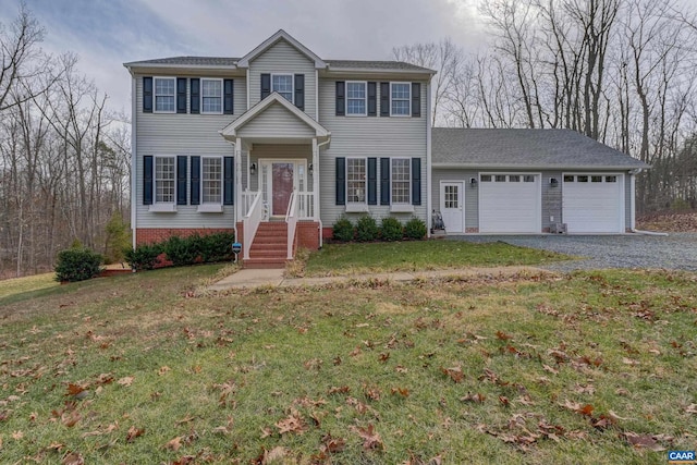 colonial home with a garage and a front lawn