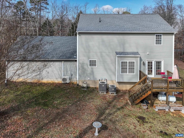 rear view of house with central AC unit, a yard, ac unit, and a deck