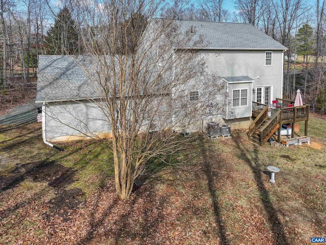 back of property with a lawn and a deck